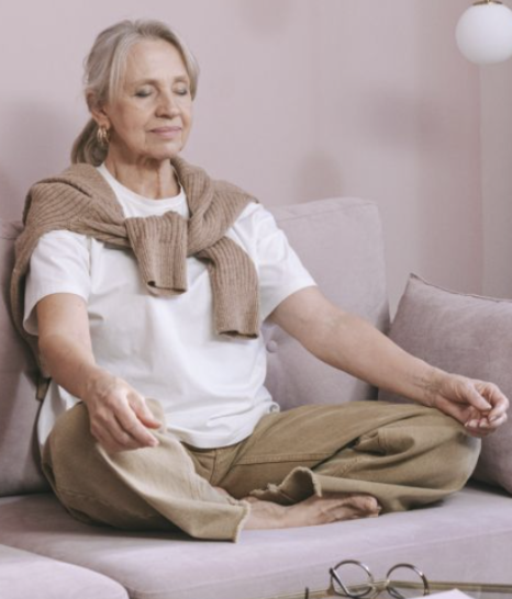 Femme qui médite pour profiter des bienfaits de la pause digestive et retrouver le repos après le repas