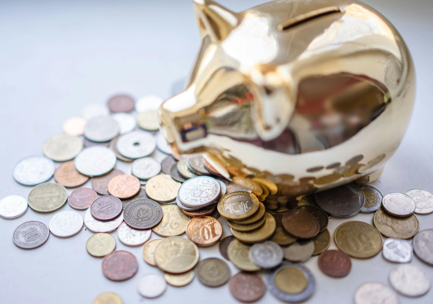 pieces de monnaie et tirelire pour illustrer le cout des examens des troubles digestifs et du SIBO